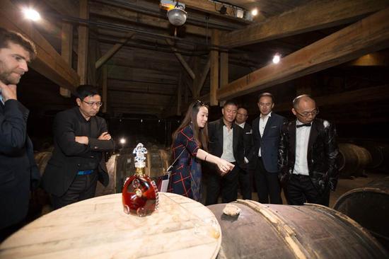 路易十三傳訊經理史佳瓊（左三）向好友們介紹用于陳釀生命之水的專屬蒂爾肯橡木桶。它由樹齡達150年的利木贊橡木制成，是成就路易十三傳奇的獨特珍寶，除路易十三之外任何干邑都無此殊榮。
